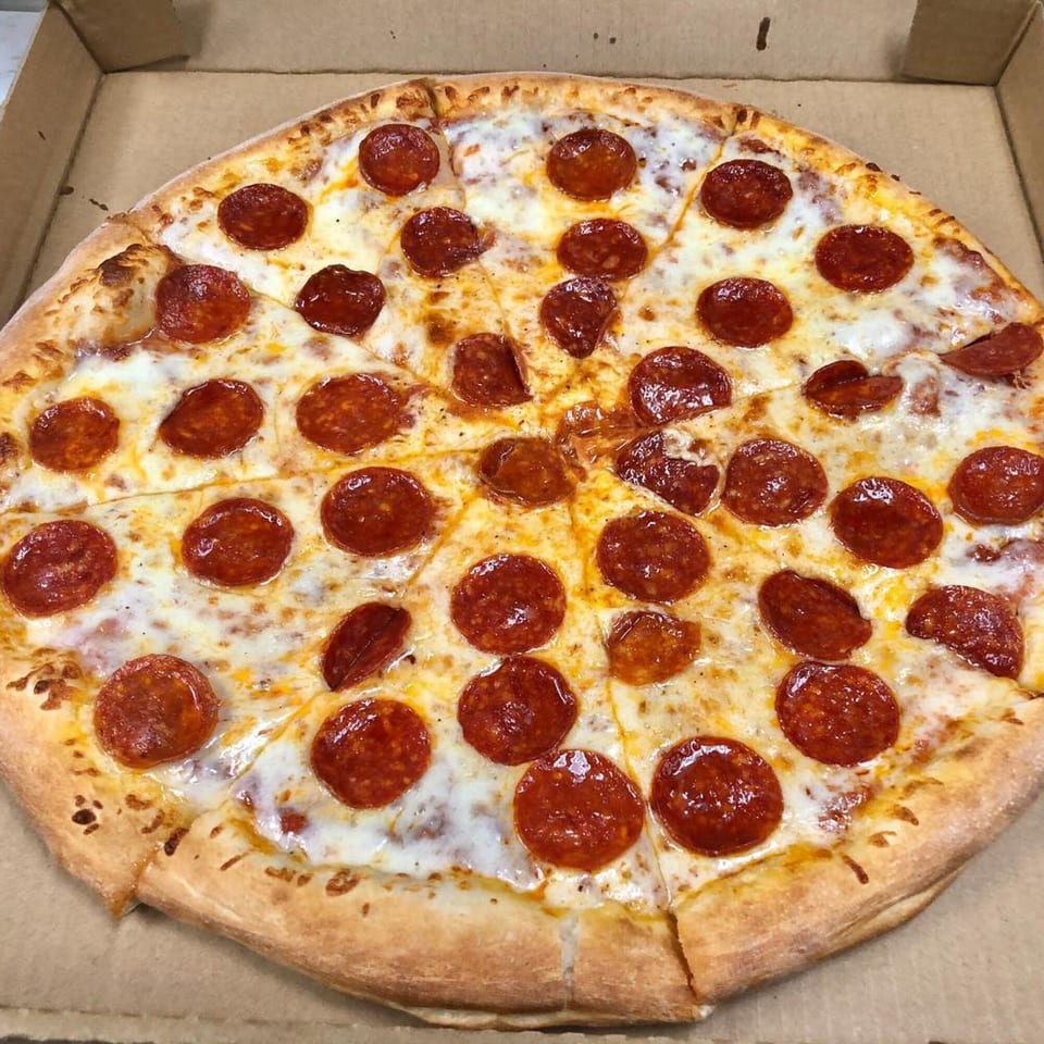 A whole pepperoni pizza from Marco Polo Pizza, with melted cheese and a golden crust, in a cardboard box.